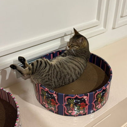 Cat lying on a decorative cat bed with a striped pattern.